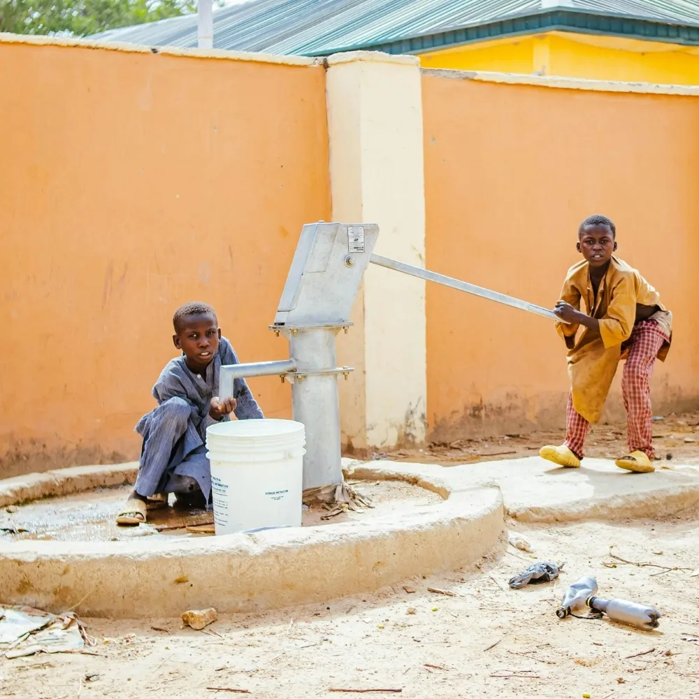 Two boys at a water well